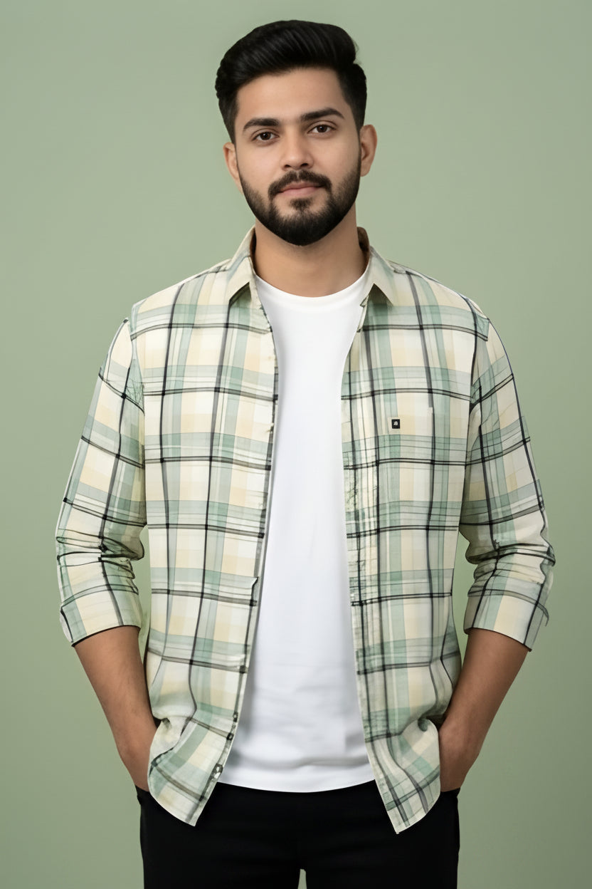 Man wearing a plaid shirt over a white t-shirt against a green background
