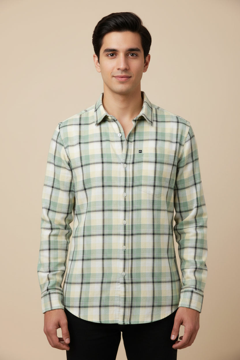 Plaid shirt with green, white, and black pattern on a plain background