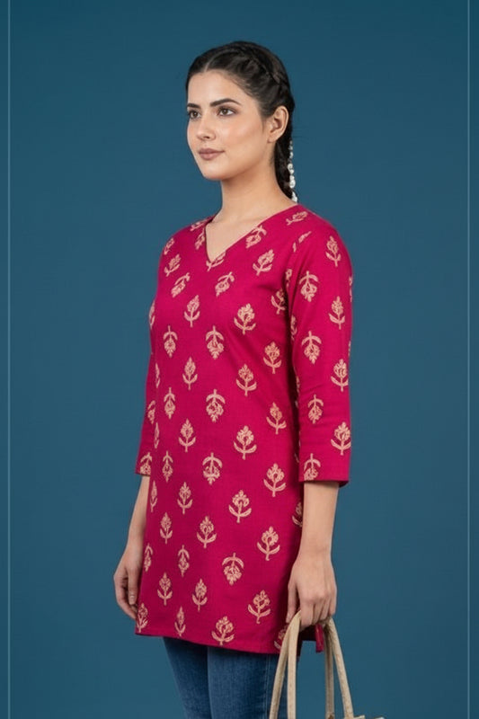 Woman wearing a pink patterned SHORT kurta against a blue background